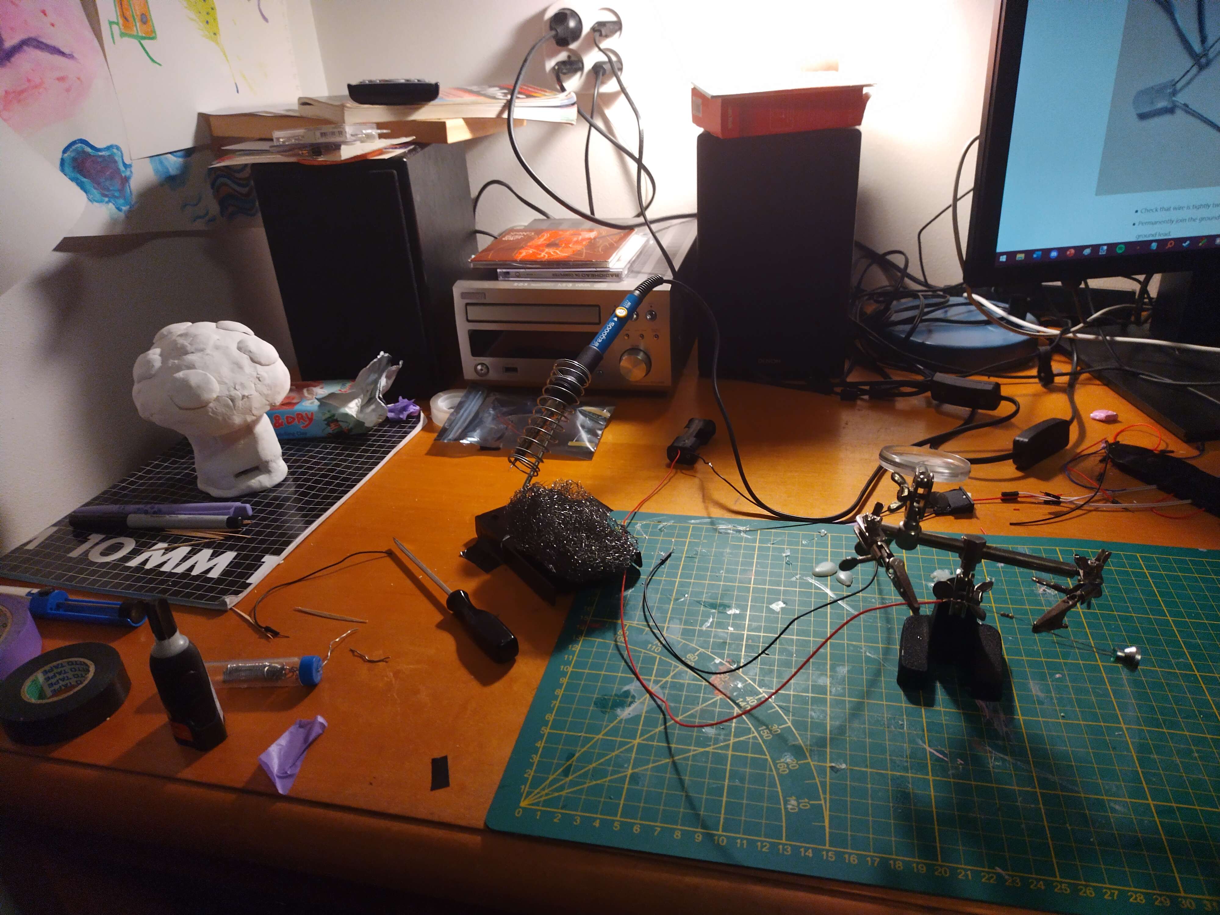 A picture of my desk with lots of soldering and sculpting stuff on it.